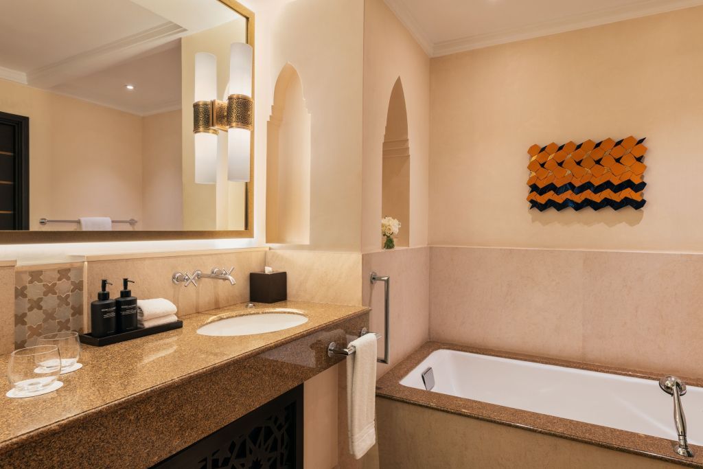 Elegantes Badezimmer mit Badewanne und stilvollen Leuchten im Vier Jahreszeiten Resort.