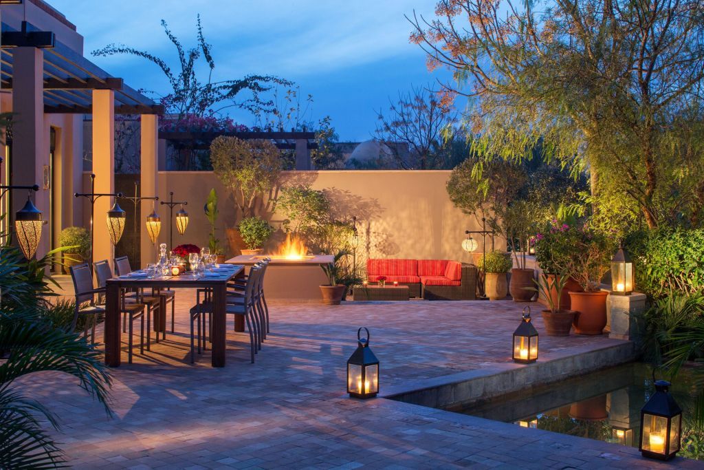 Abendstimmung auf der Terrasse mit Pool Design Möbeln und romantischer Beleuchtung