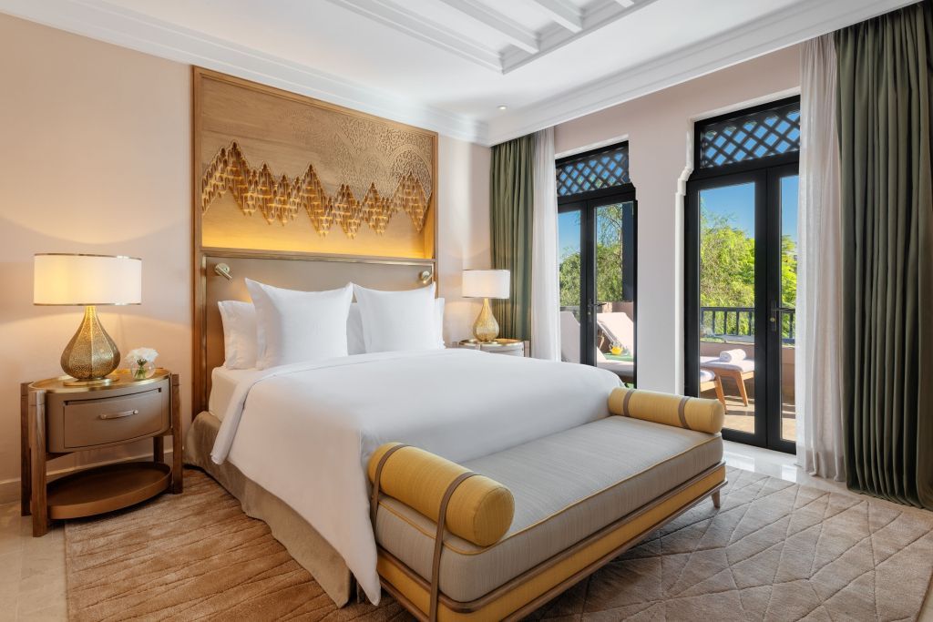 Helles Schlafzimmer mit Zugang zur Terrasse und Gartenblick.