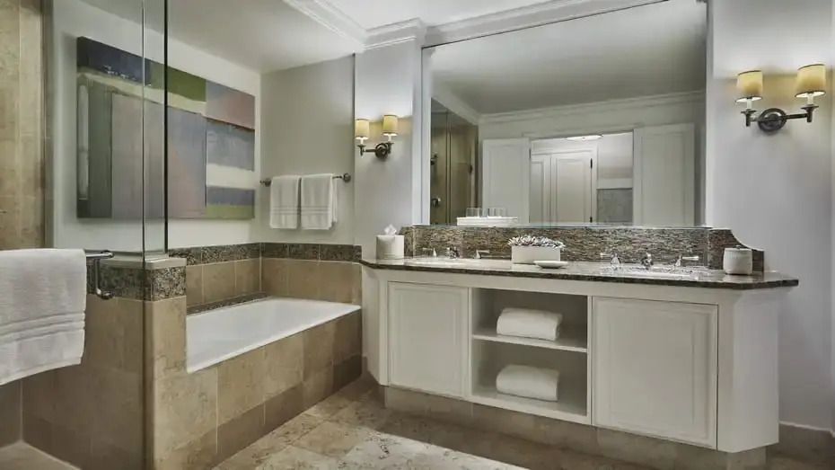 Modernes Badezimmer mit Badewanne und großem Spiegel. Dezente Beleuchtung