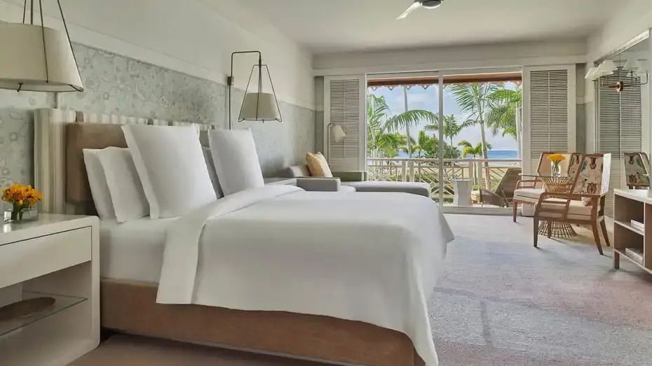 Geräumiges Schlafzimmer mit Doppelbett, Blick auf Balkon und Palmen