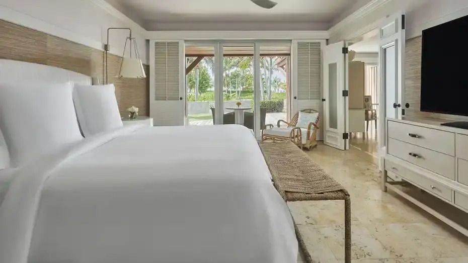 Grosszügiges helles Schlafzimmer mit Doppelbett und Blick auf Terrasse im Four Seasons Resort Nevis