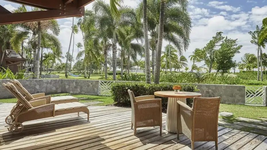 Terrasse mit Holzdeck und Sitzbereich umgeben von Palmen im Four Seasons Resort Nevis