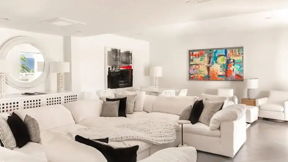 Heller Wohnbereich mit großzügigem Sofa und moderner Kunst