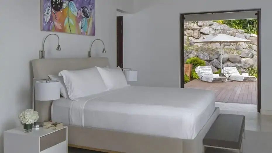 Helles Schlafzimmer mit Doppelbett und Kunstwerk an der Wand