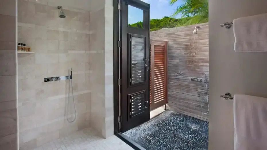 Luxuriöses Badezimmer mit offener Dusche und Holztür
