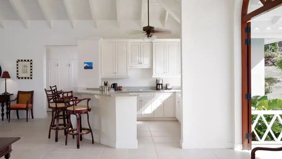 Helle Küche mit Barhockern und Kaffeemaschine in Villa