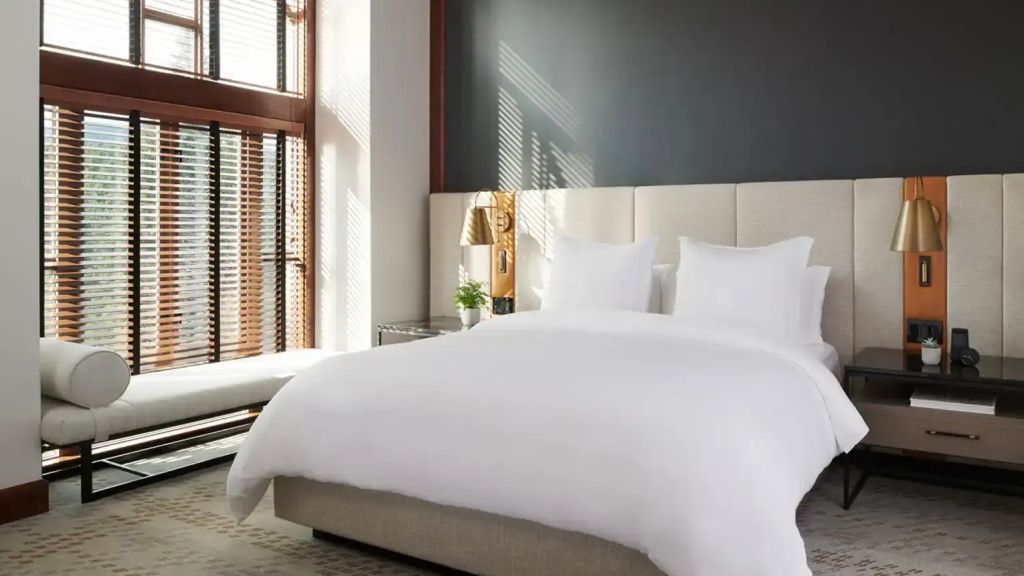 Modernes Hotelzimmer mit großem Doppelbett und eleganter Einrichtung