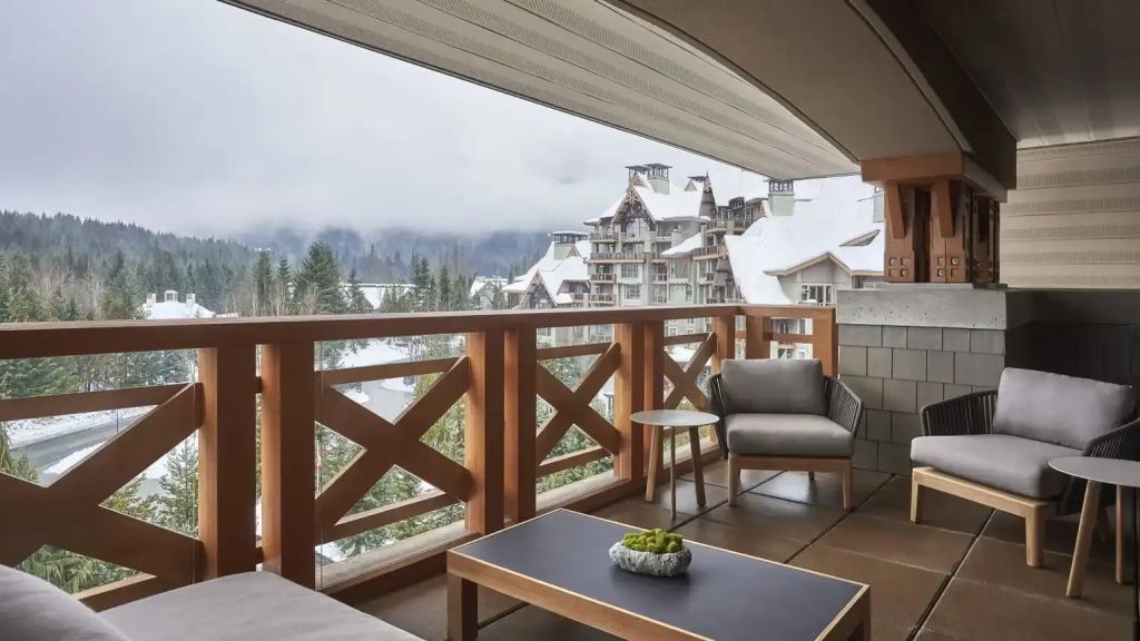 Privater Balkon mit malerischer Aussicht auf verschneite Berge und Gebäude