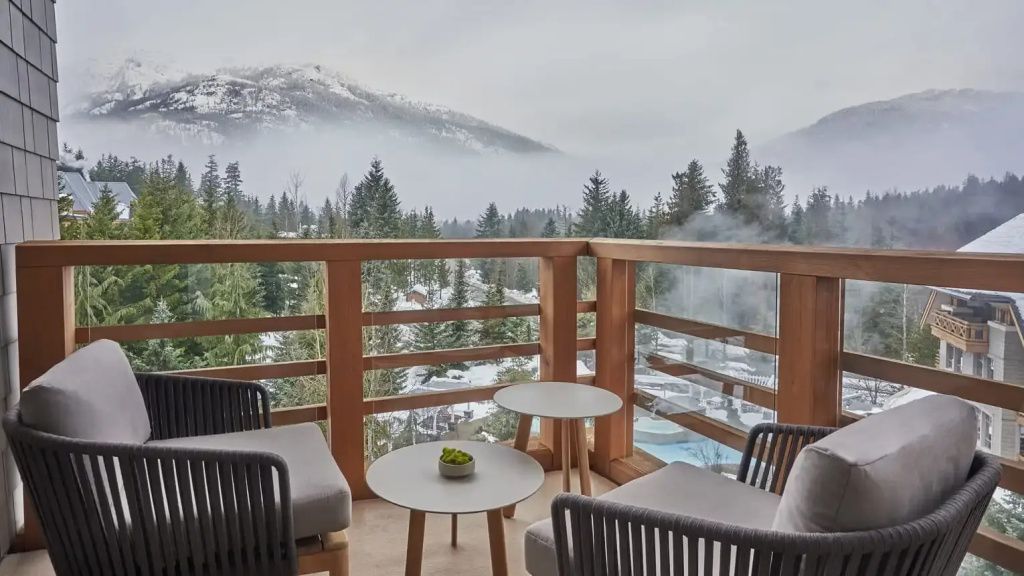 Balkon mit Panoramablick auf die verschneiten Berge und Wälder