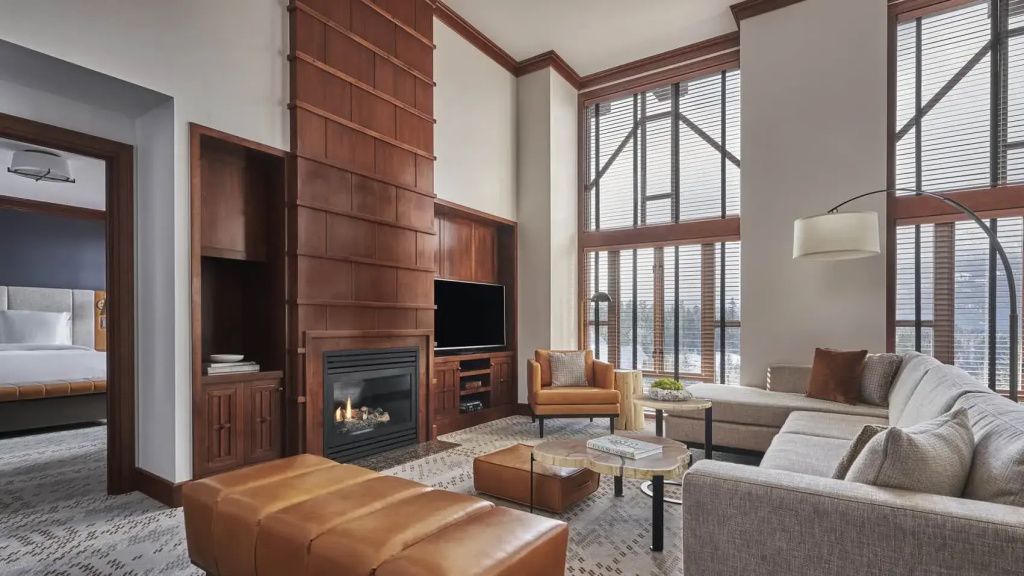 Elegantes Wohnzimmer der Summit Suite mit Kamin und großen Fenstern