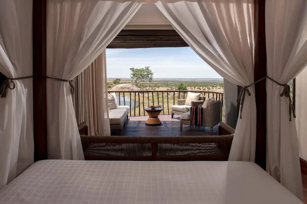 Gemütlicher Balkon mit Sitzmöbeln und Blick auf die afrikanische Landschaft