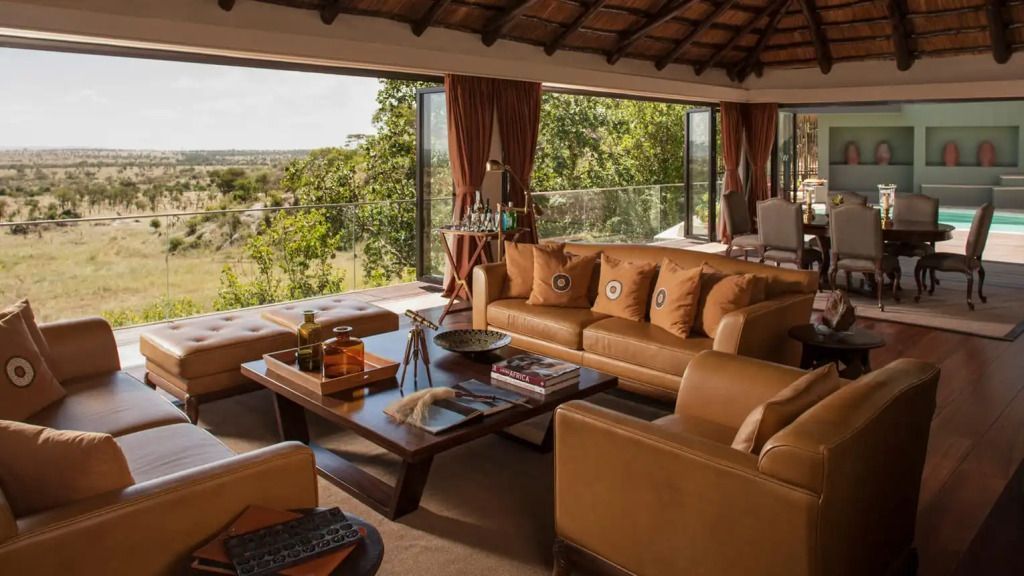 Gemütlicher Wohnbereich mit Sofas und großen Fenstern zur umgebenden Natur.