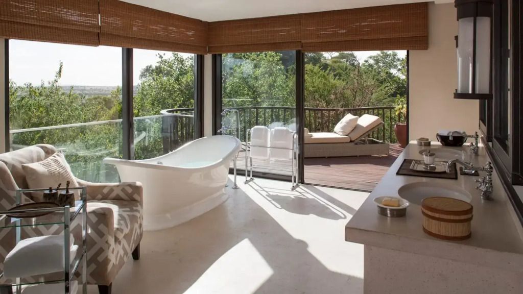 Helle Villa mit freistehender Badewanne und Terrasse mit Liegestuhl im Grünen