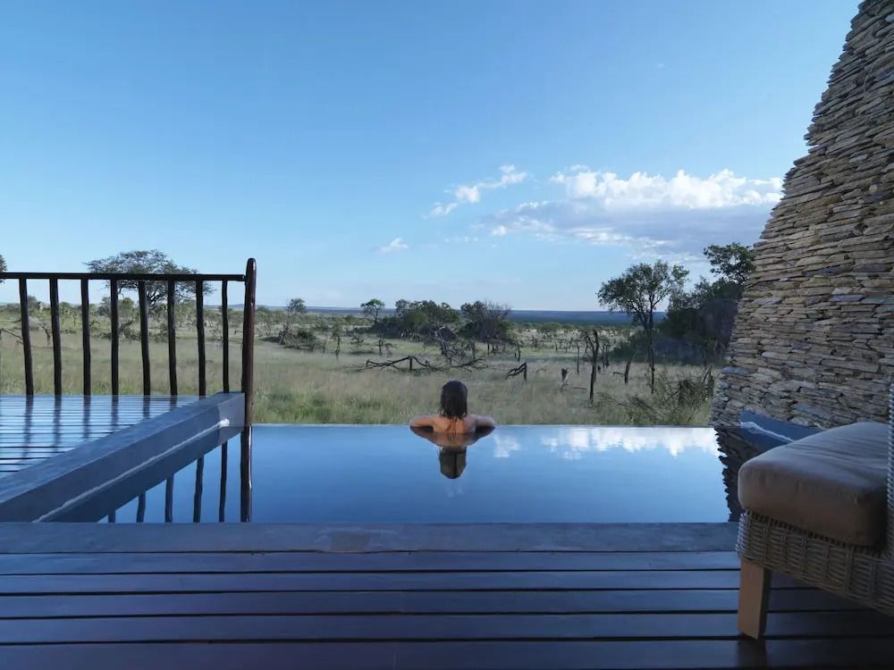 Gäste genießen Infinity-Pool mit Blick auf die weite Landschaft der Serengeti