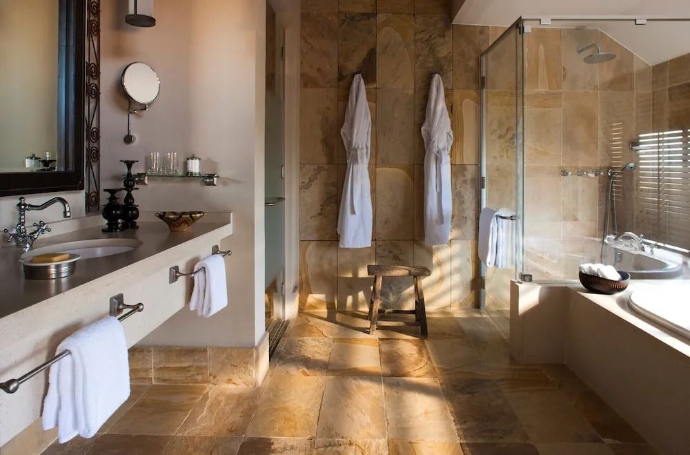 Eleganter Spa-Bereich mit Dusche und Bademänteln auf Steinfliesenflur