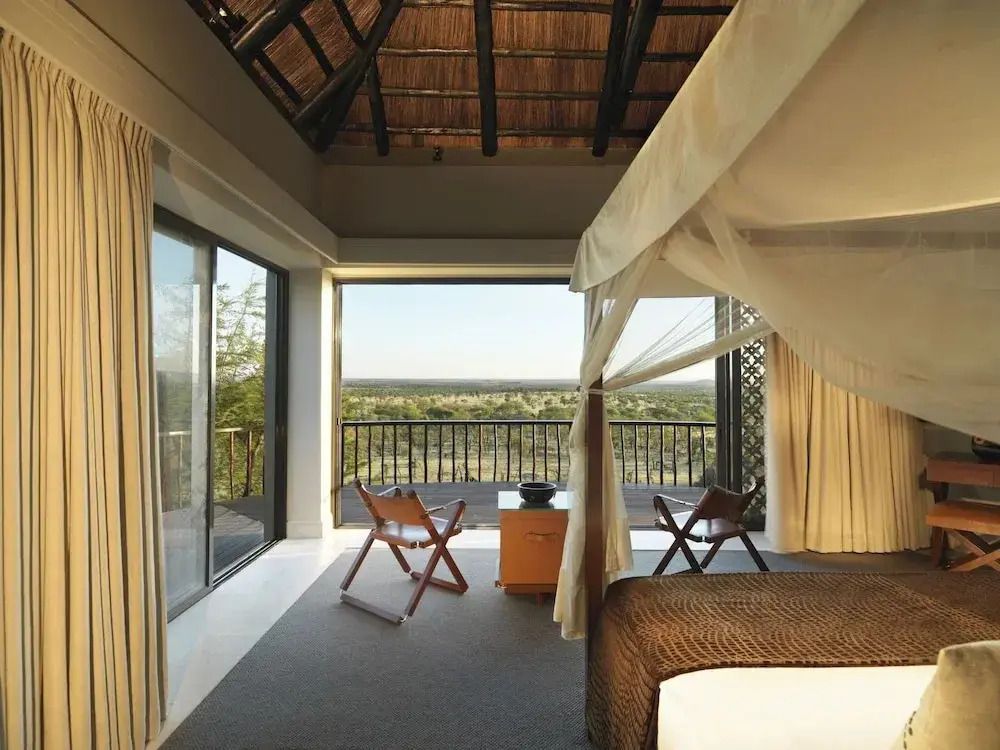 Geräumiges Schlafzimmer mit Panoramablick und Himmelbett in der Safari Lodge Serengeti