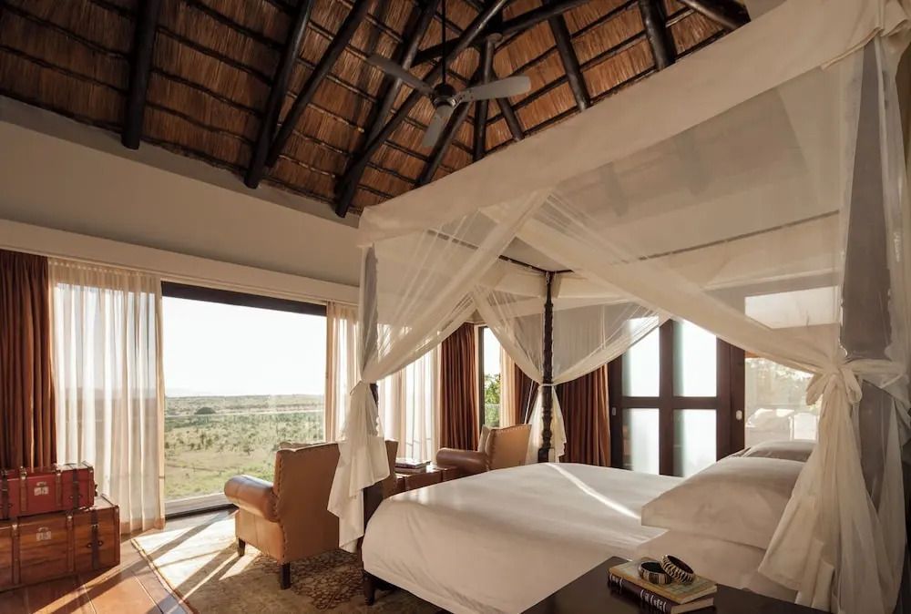 Elegantes Schlafzimmer mit Himmelbett und Ausblick auf die weite Landschaft