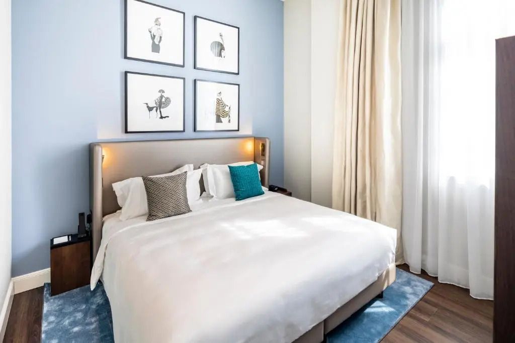 Luxuriöses Doppelbett im Fraser Suites Hamburg mit stilvoller Wandkunst