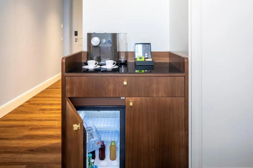 Minibar mit Getränken und Kaffeemaschine im Deluxe Zimmer im Fraser Suites Hamburg