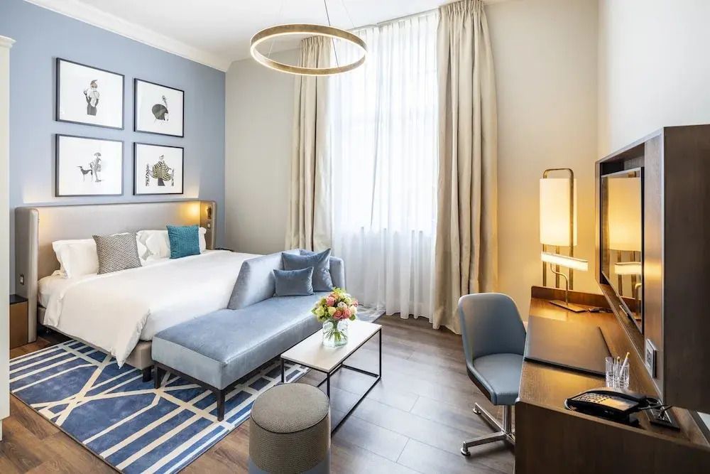 Wohnbereich mit Sofa, Schreibtisch und großen Fenstern