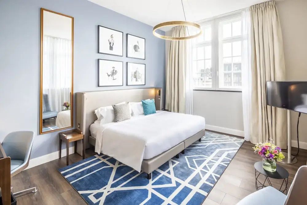 Schlafzimmer mit großem Bett, Wanddekoration und natürlichem Licht
