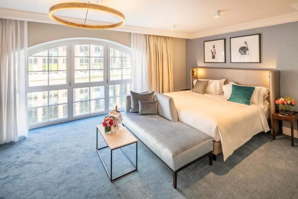 Gemütliches Schlafzimmer mit großen Flügeltüren und Sitzbereich in Fraser Suites Hamburg.