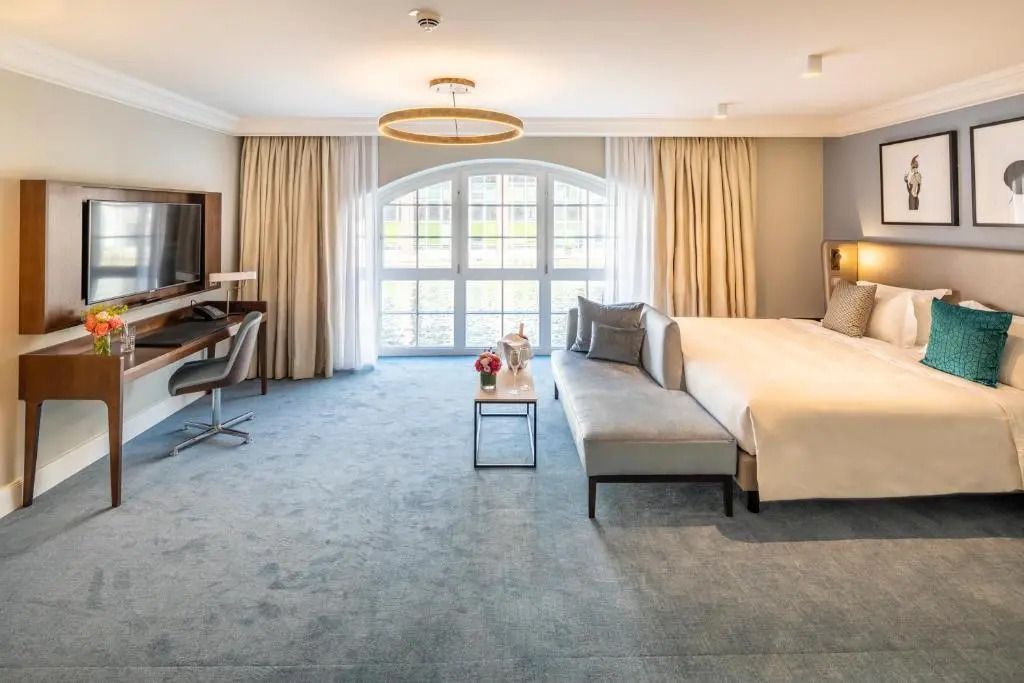 Geräumiges Schlafzimmer mit moderner Einrichtung und großem Fenster in Fraser Suites Hamburg.