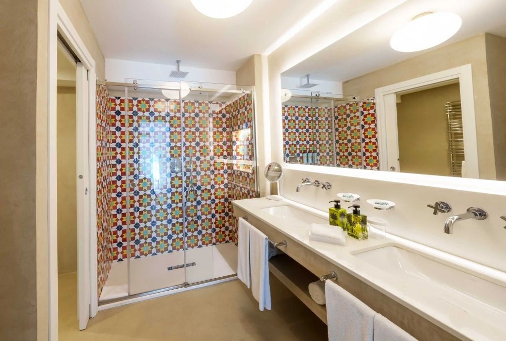 Badezimmer mit bunter Mosaik-Dusche und Doppelwaschbecken