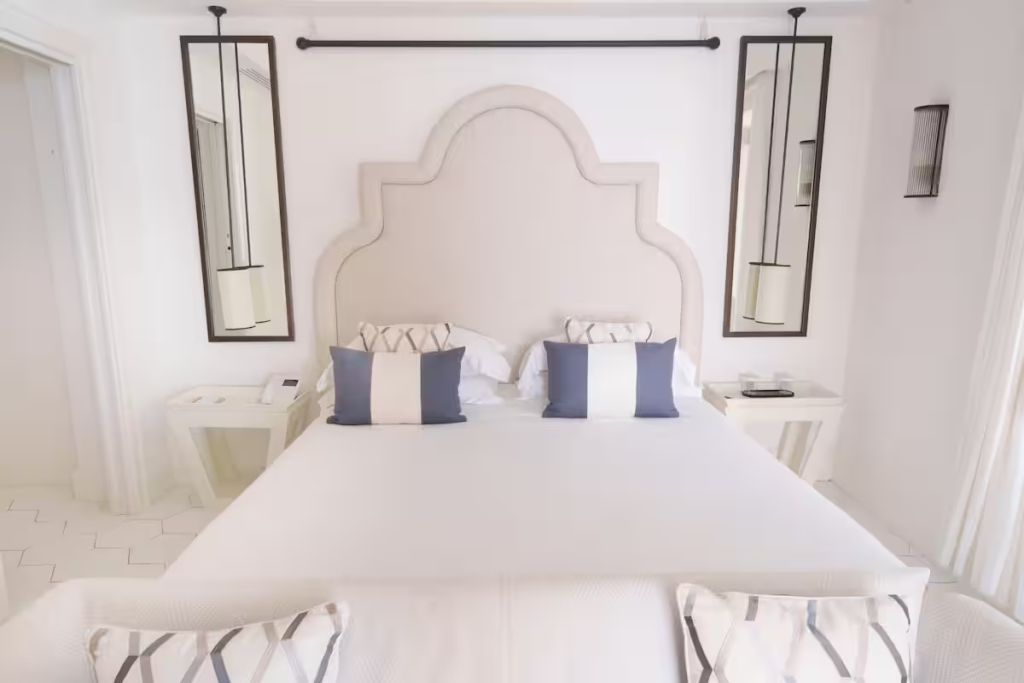 Luxuriöses Bett mit großen Spiegeln und Kissen in eleganter Suite