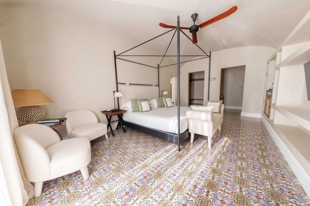 Elegant eingerichtetes Schlafzimmer mit Himmelbett und Designer-Fliesenboden