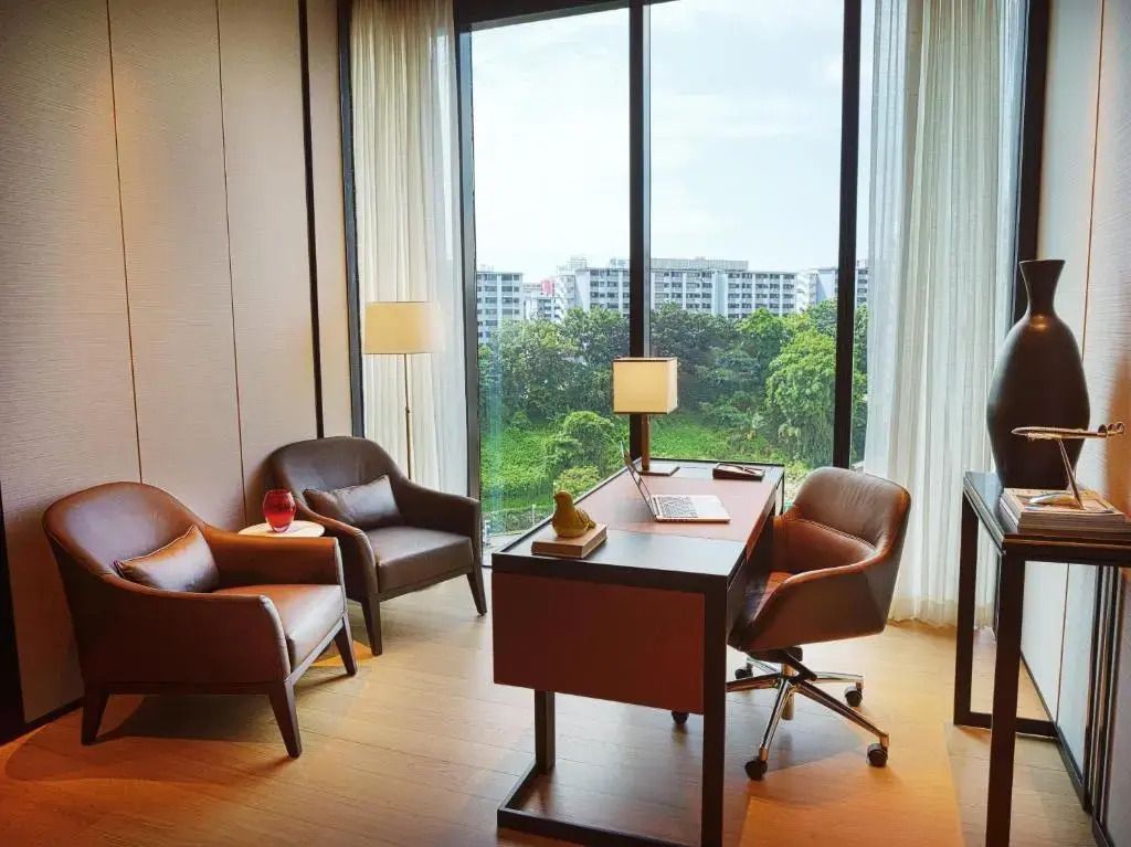 Schreibtischbereich im Penthouse mit großen Fenstern und zwei Sesseln