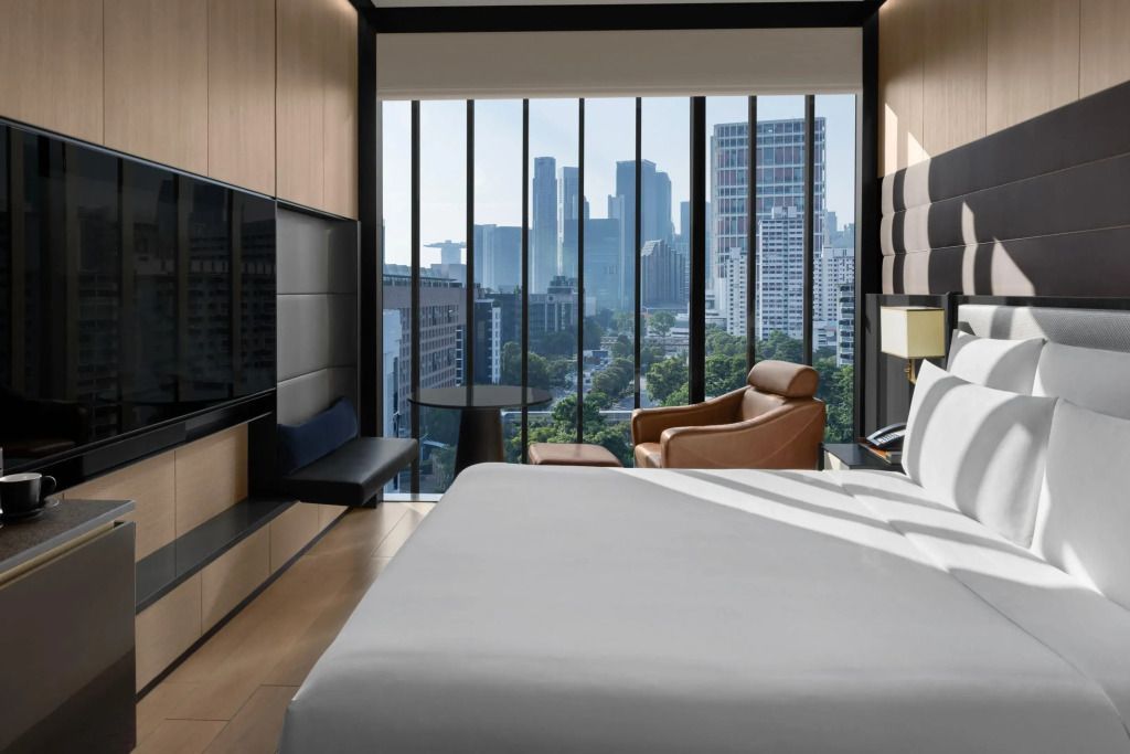 Helles Zimmer mit Doppelbett und Panoramafenster mit Stadtblick