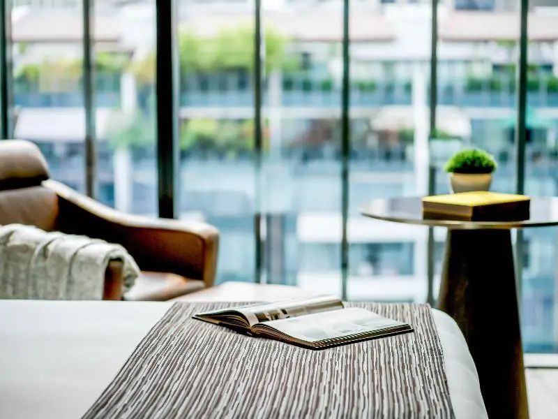 Offenes Buch und stilvolle Einrichtung in einem Zimmer mit großem Fenster