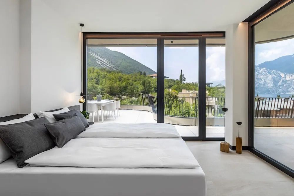 Schlafzimmer mit Doppelbett und Zugang zu einem Balkon mit Aussicht auf die umliegende Landschaft