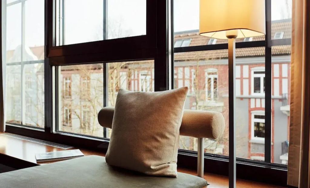 Entspannungsbereich mit Kissen und Lampe vor großem Fenster