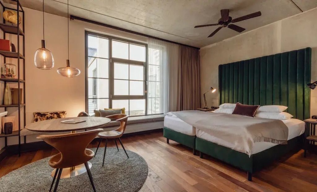 Helles Doppelzimmer mit großem Fenster und Holzboden