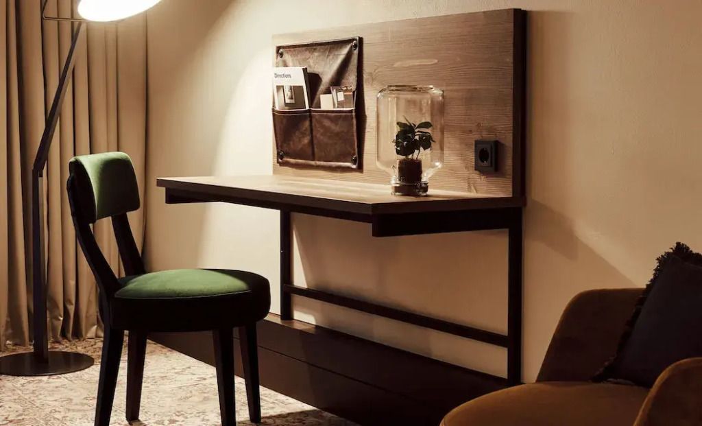 Moderner Schreibtischbereich mit Beleuchtung und Sitzgelegenheiten im Gastwerk Hotel Hamburg.