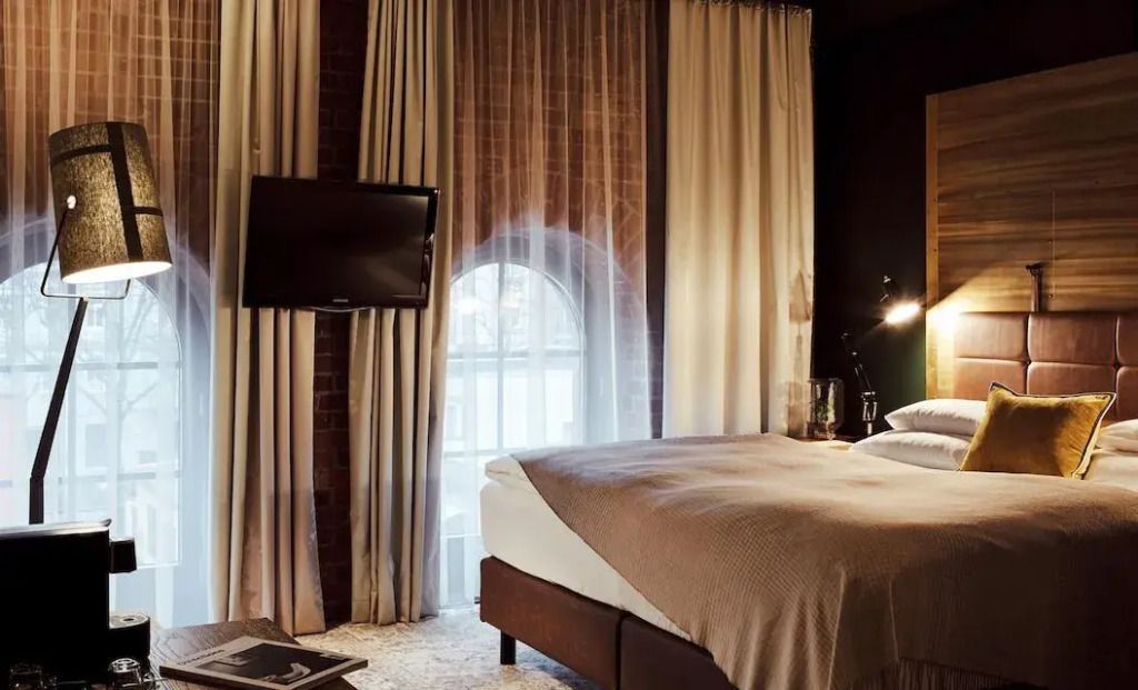 Elegantes Doppelzimmer im Gastwerk Hotel mit einem großen Fenster und Flachbildfernseher
