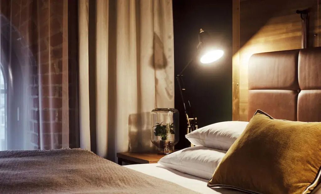 Gemütlicher Schlafbereich im Gastwerk Hotel mit Leselampe und Dekoration