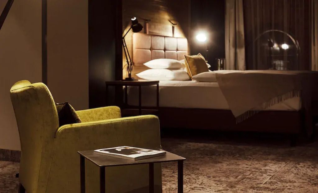 Helles Schlafzimmer mit Doppelbett und Leseecke im Gastwerk Hotel Hamburg
