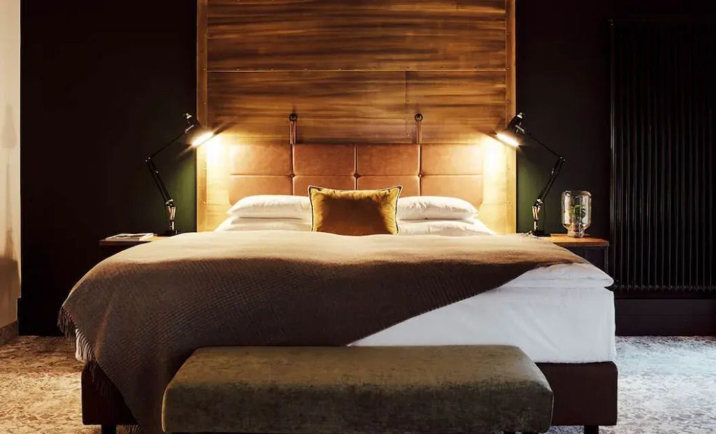 Luxuriöses Doppelbett mit Holzrückwand und Leselampen im Gastwerk Hotel Hamburg