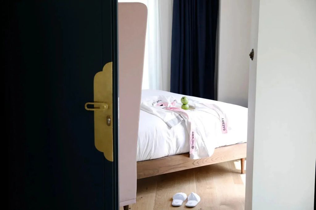 Elegante Suite mit Doppelbett und Hausschuhen vor dem Bett