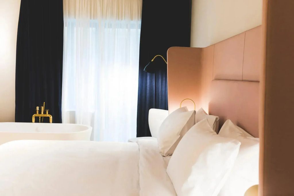 Helles Zimmer mit großem Doppelbett und stilvollen Vorhängen