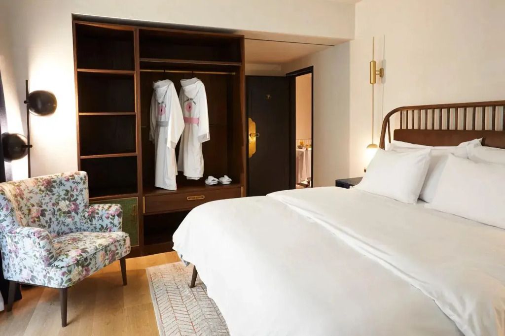 Hotelzimmer mit offenem Kleiderschrank und weichen Bademänteln neben einem komfortablen Bett