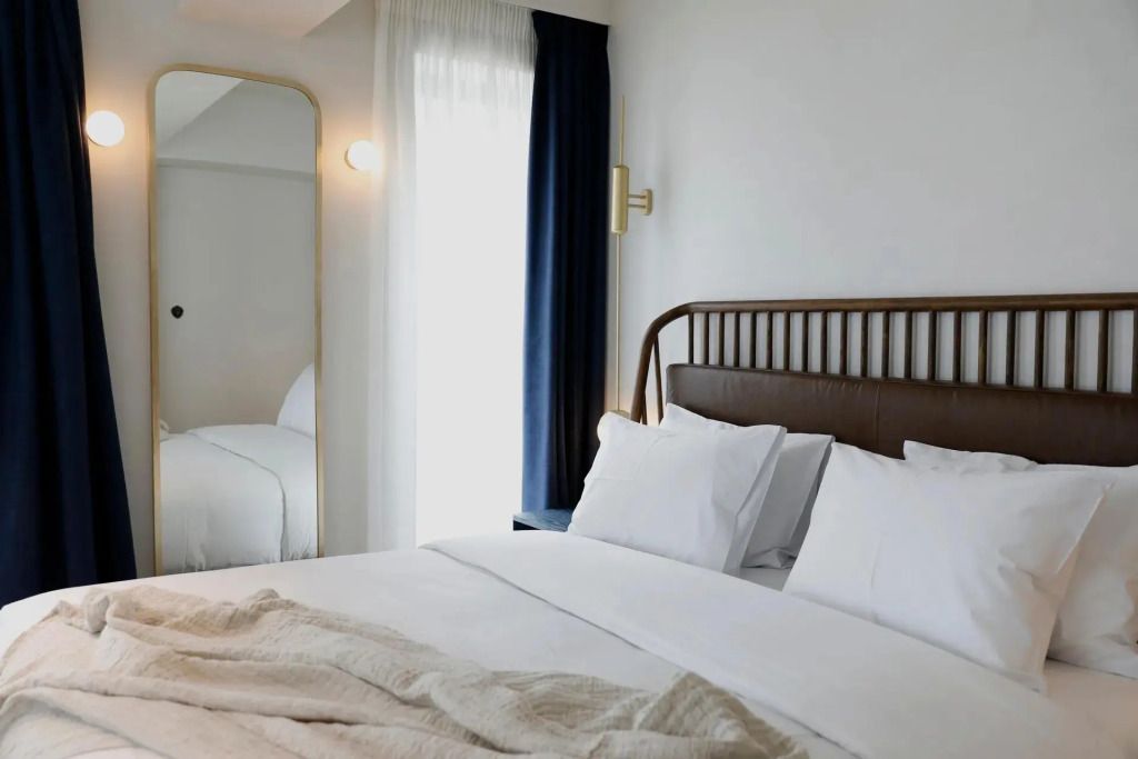 Modernes Doppelbett mit eleganter Kopfstütze und Tagesdecke in neutralen Tönen