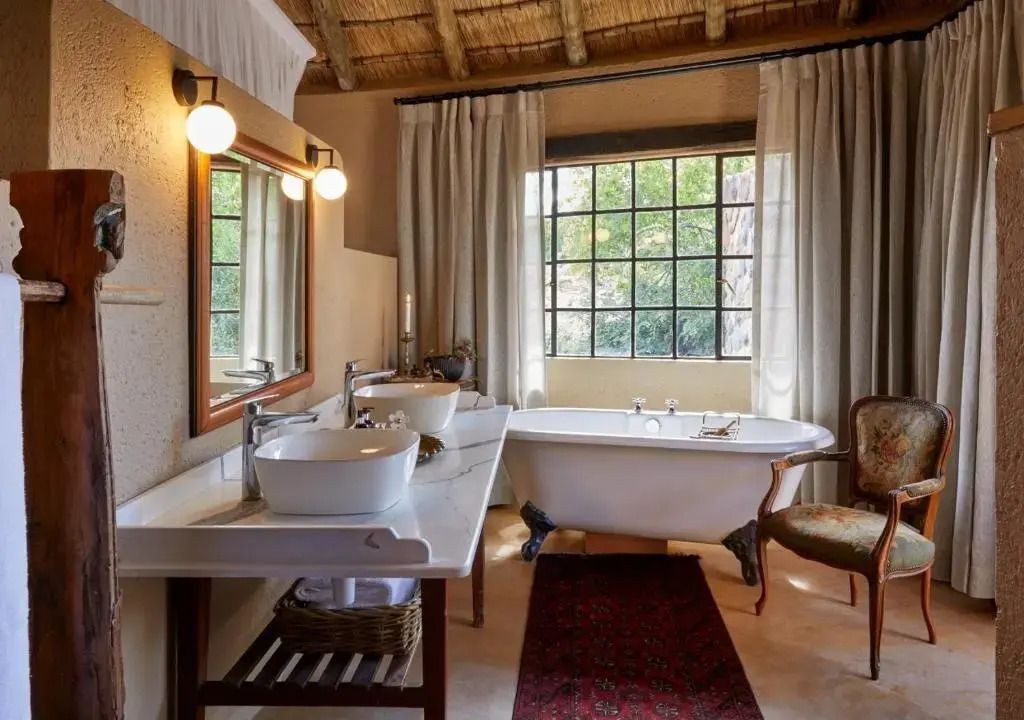 Elegantes Badezimmer mit freistehender Badewanne und großer Fensterfront.