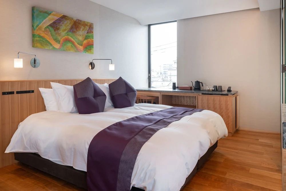 Deluxe Zimmer mit großem Bett und modernem Kunstwerk
