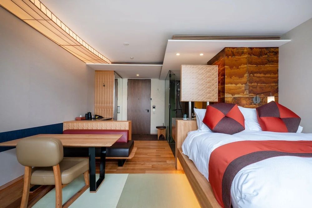 Deluxe Zimmer mit Bett und kleinem Essbereich aus Holz