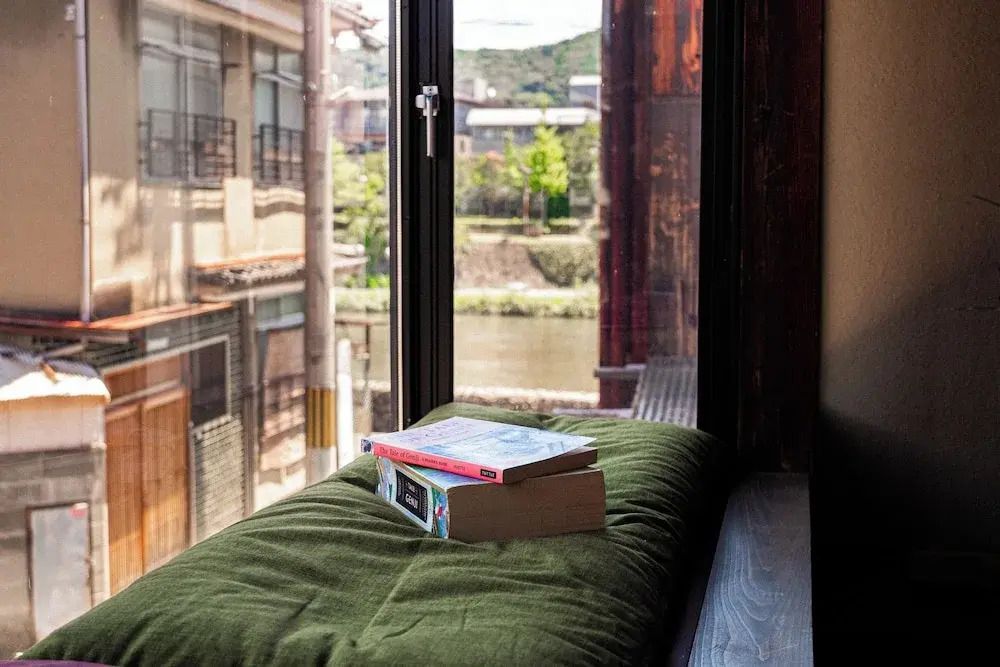 Fenstersitz mit Kissen und Büchern sowie Blick auf die Umgebung
